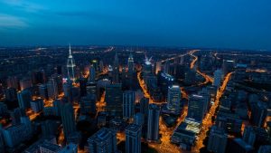 Oraș iluminat cu multe clădiri interconectate dominând zona.